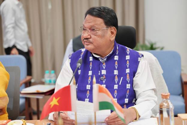 A person sitting at a desk with flagsAI-generated content may be incorrect.