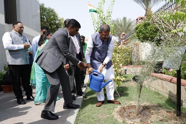 A group of men watering a tree