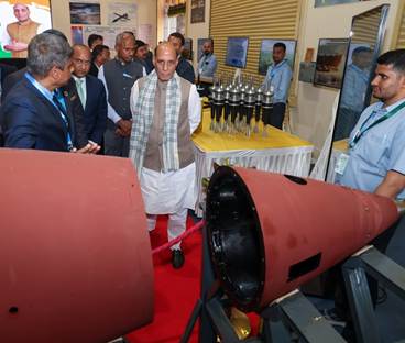 A group of people standing around a red objectDescription automatically generated