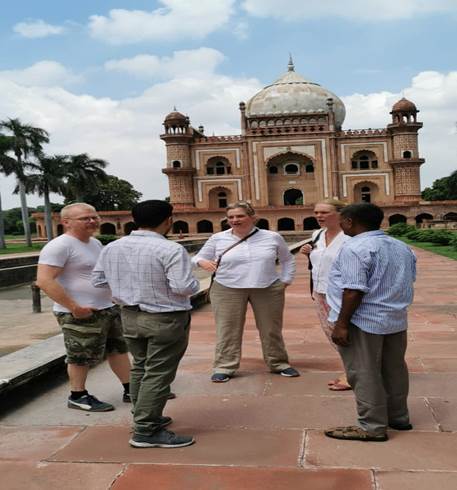 A group of people standing in front of a buildingDescription automatically generated