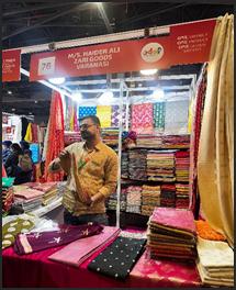 A person standing in front of a display of colorful fabricsAI-generated content may be incorrect.