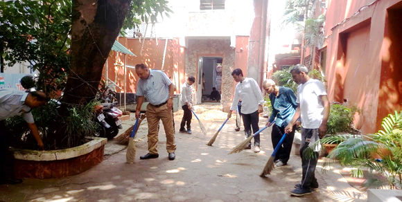 A group of people sweeping the groundAI-generated content may be incorrect.